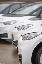 Close-up of parked white electric cars, focus on headlights, ID3, Deer e-car sharing, Germany