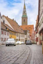 Historic old town with cobblestones and colorful houses, a church tower in the background, ID3,