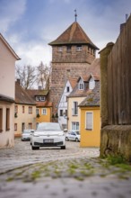 Narrow alley with cobblestones and old defensive towers in a village, ID3, deer e-car sharing,