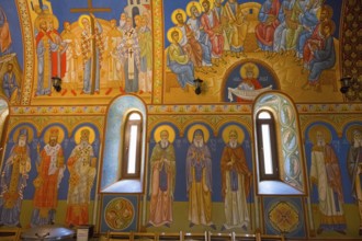 Orthodox church with glowing frescoes and saints, conveys a spiritual atmosphere, St. Barbara