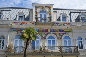 Detailed view of a building with colorful ornaments and palm trees in front of the balcony, Europe