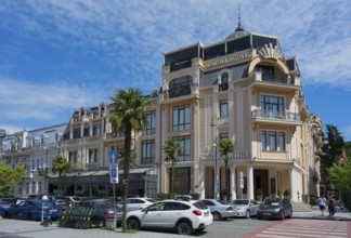Elegant building with decorated facades and palm trees in front of a parking lot, Royal Casino and