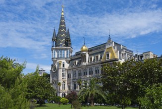 Castle-like building with tall tower and green garden under blue sky, Astronomical Clock, Black