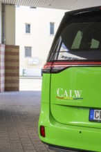 Green car in city scene with 'Calw' lettering on the back, Deer E-Mobility Shuttle Service, Calw,