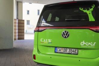 Volkswagen in green with lettering on the back in an urban environment, Deer E-Mobility Shuttle