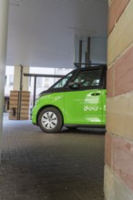 Green car in a covered area of a modern city, Deer E-Mobility Shuttle Service, Calw, Germany