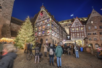 Christmassy illuminated square with the historic Pilate House with advent calendar, in the evening