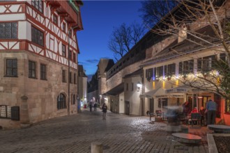 The old city wall with rampart, on the left the historic Dürerhaus, in evening lighting, Beim