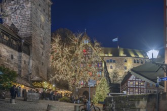Christmassy illuminated square with the historic Pilate House with advent calendar, in the evening