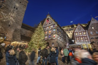 Illuminated Christmas tree with the historic Pilate House with advent calendar, in the evening