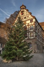Decorated Christmas tree in front of the historic Pilate House with advent calendar in the evening