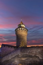 Illuminated Sinwell tower in the evening sky, built in the 13th century, Kaiserburg, Nuremberg,