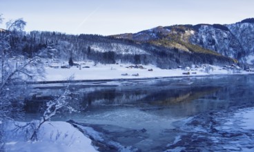 Snowy landscape with hills and river in winter, Norway
