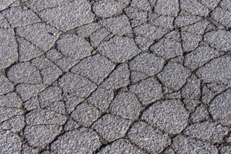 Asphalt surface, floor, with many small cracks, roadway, parking lot
