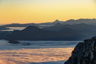 Sunrise in the mountains, view of Salzburg with fog, silhouette of mountain ranges in the back,