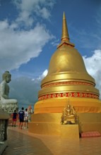 People, Buddha statue, chedi in Wat Tam Sua monastery, which is partly on the top of a mountain,