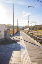 Station with sunshine and empty tracks in urban surroundings, Weil der Stadt station, Germany