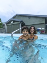 Mother and son are smiling and having fun while bathing in miette hot springs, located in the