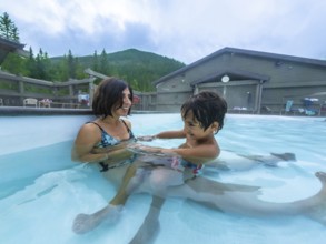 Mother and son are enjoying time together, playing in the warm, soothing waters of miette hot