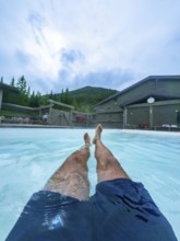 Tourist relaxing in the miette hot springs, surrounded by the breathtaking beauty of jasper