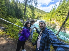 Family taking a selfie against the stunning backdrop of turquoise waters cascading over overlander
