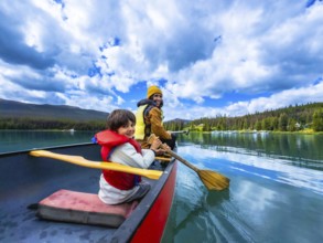 Father and son are paddling a canoe on beautiful maligne lake in jasper national park, alberta,