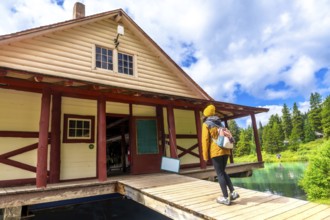 Hiker standing on the wooden pier of the boathouse at maligne lake enjoying the breathtaking view