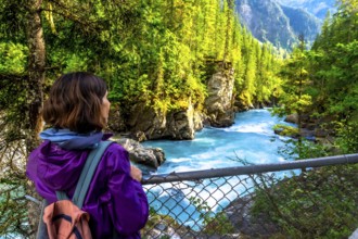 Female hiker enjoying the breathtaking turquoise waters of the fraser river cascading through the