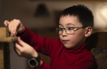 Boy, 6 years, glasses, multi-ethnic, plays concentrated, constructs, builds, Stuttgart,