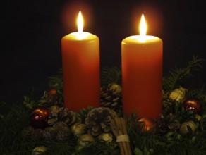Festive advent wreath with two burning candles, pine cones, pine cones, pine branches, cinnamon