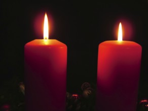Two burning red candles create a calm and contemplative atmosphere in the dark, Advent wreath with