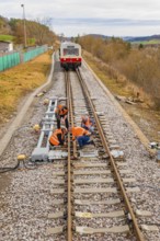Workers carry out maintenance work on railroad tracks, historic event, first test run with a