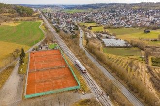 Train line and tennis courts on the outskirts of the city in hilly countryside, historic event,