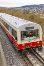 Side view of a moving train on the rails with an urban landscape in the background, historic event,