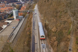 A station with a train that stops on the tracks while the autumn surroundings are visible, historic