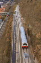 Train on tracks along hills across a bridge in a winter environment, historic event, first test run