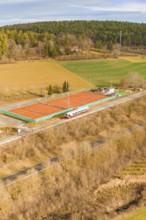 Land view of tennis courts next to a moving track, historic event, first test run with a passenger