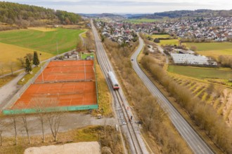 Panorama of a rural area with train next to tennis courts, historic event, first test drive with a