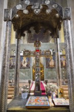 Richly decorated church altar with holy icons and cross surrounded by flowers, Svetitskhoveli