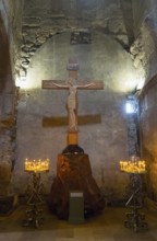 Interior of a church with a wooden cross and candlesticks on both sides, intimate religious
