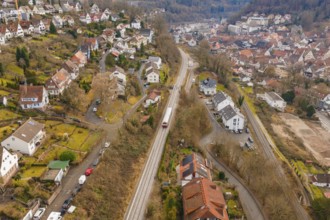 City with close-standing houses along a railway line through hilly, wooded landscape, historic