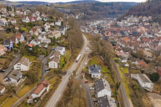 Urban landscape with railway line through hills with various houses and trees, historic event,