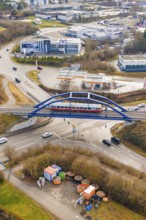 A train crosses a bridge over a roundabout in an urban environment, historic event, first test run