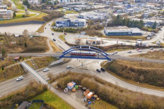 A train crosses a busy road junction in the city on a bridge, historical event, first test drive