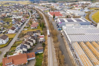 Cityscape with a train traveling through a mix of residential district and industrial area,