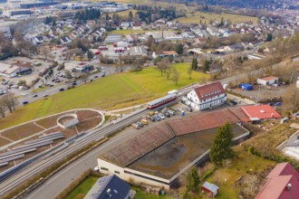 A train at a large train station, surrounded by residential buildings and roads, historic event,