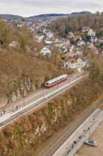 Train waiting at a village station, nestled in hilly rocky landscape in winter, historic event,