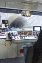 View of a tunnel from the train driver's cab, with technical equipment and control panel in the