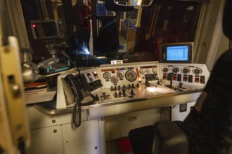 Train driver stand at night, illuminated controls and monitors with an insight into the technology