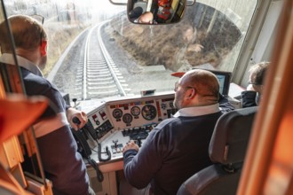 Team in the driver's cab of a train, looking at the railway tracks in front of them, historic